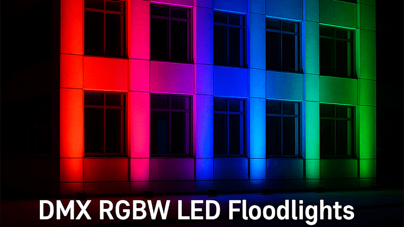 A modern building facade at night dramatically lit with colorful DMX RGBW LED floodlights.