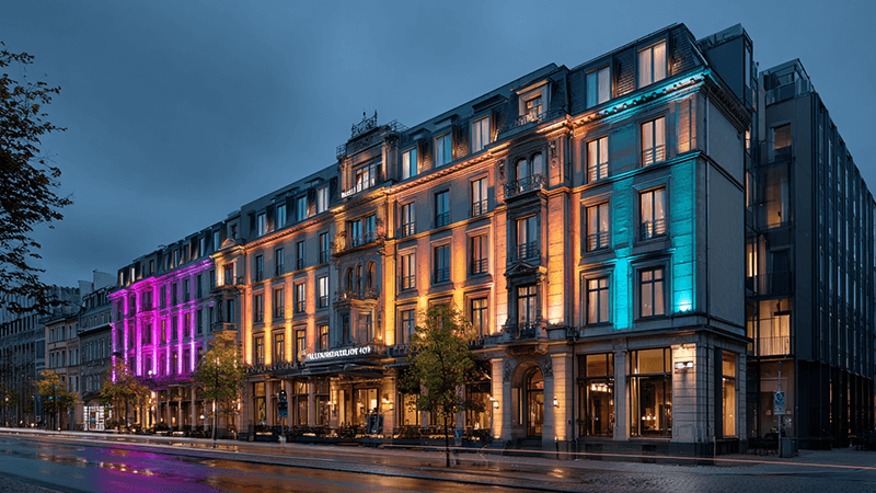 A luxurious hotel facade at night, beautifully illuminated with dynamic colors from RGBW LED floodlights
