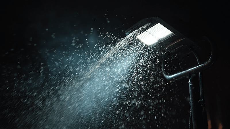Water being sprayed on an IP-rated LED floodlight
