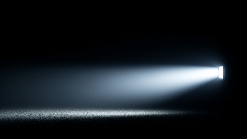 alt with keywords: A strong beam of light acting as a visible barrier in the dark