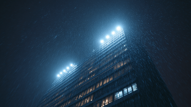 A building facade illuminated at night with IP65-rated LED floodlights during a rain shower.