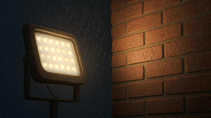An outdoor floodlight illuminating a building facade in the rain
