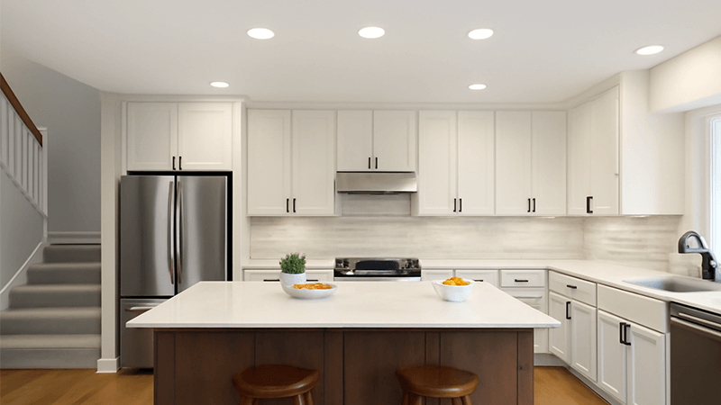 A kitchen island lit by functional recessed downlights.