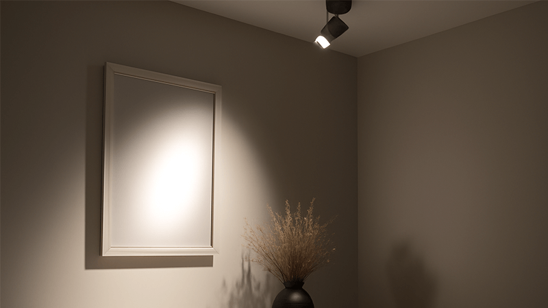 A room where a spotlight creates a harsh glare on a reflective surface and deep shadows behind an object.