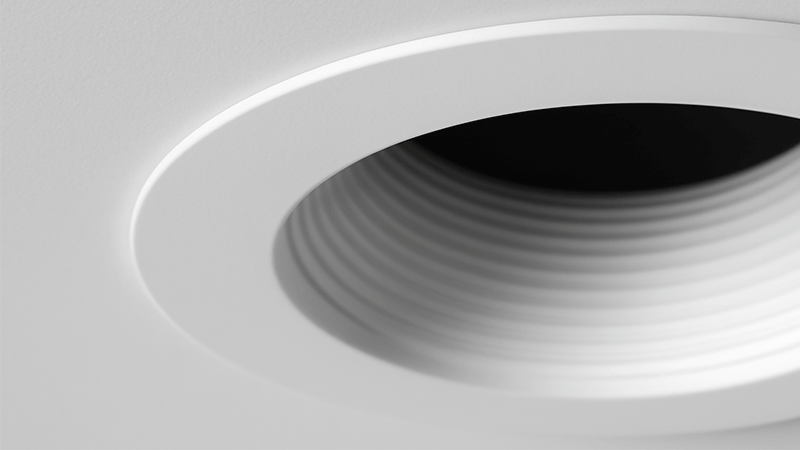 A close-up shot of a downlight trim, highlighting the flange and baffle