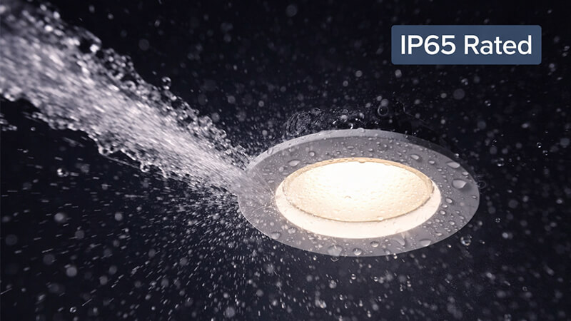 A downlight being tested with a jet of water to show its IP65 rating