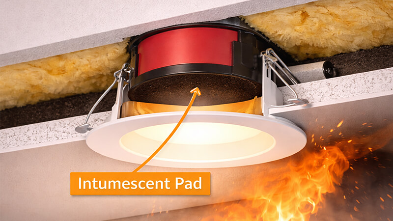 A cross-section view of a fire-rated downlight showing the intumescent pad ready to expand.