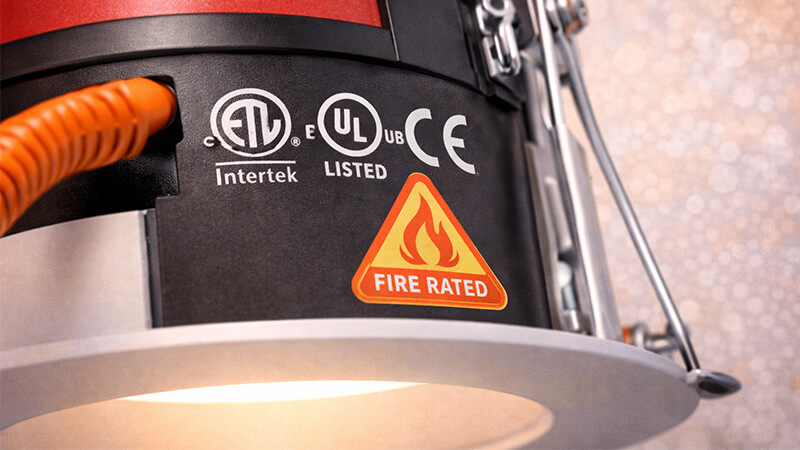 A close-up of the back of a downlight showing certification marks and a fire rating symbol.
