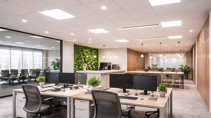 A modern office space with a mix of downlights, panel lights, and linear lights
